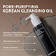 Enlarge image of A bottle of Innfree Black Volcanic Pore Purifying Cleansing Oil shown on a warm brown background with text callouts about removing waterproof makeup, sunscreen, and impurities, plus oil droplets in the scene.