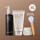 Enlarge image of The Volcanic Pore Care Routine featuring Black Volcanic PHA Pore Cleansing Oil, Volcanic BHA Pore Cleansing Foam, two light blue silicone cleansing brushes with wooden handles, and a Super Volcanic Pore Clay Mask jar, arranged on a solid brown background: save 11% and free mask applicator