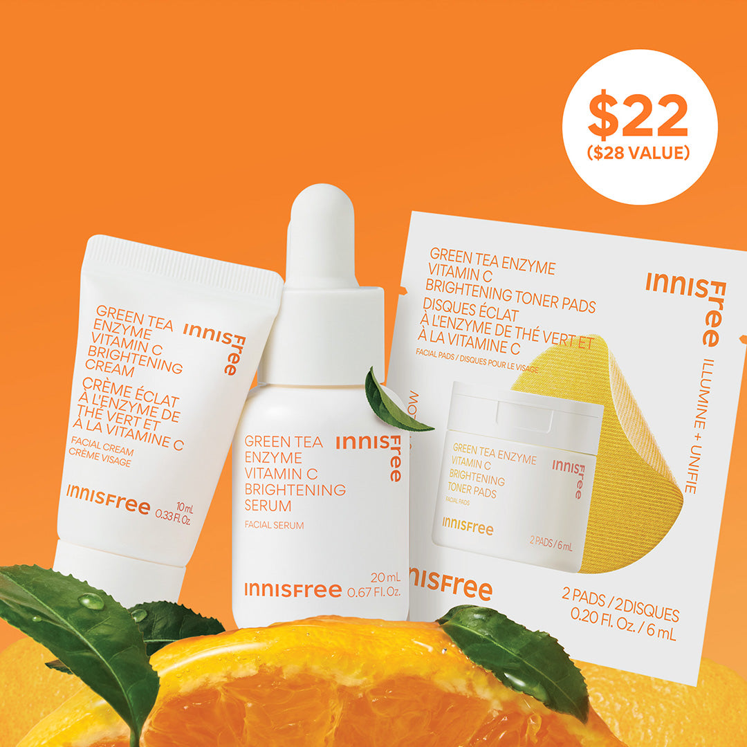 Vitamin C Rapid Brightening Minis Set displayed with orange slices and green tea leaves on a bright orange background, featuring a $22 value badge.