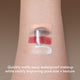 Enlarge image of Close-up of a person&amp;#39;s forearm with four makeup swatches applied: a beige cream, mascara smudge, a red lipstick layer, and a white cream. A translucent clear product is being pressed over the center, with text at the bottom reading &amp;#39;Quickly melts away waterproof makeup while visibly improving pore size + texture&amp;#39;.