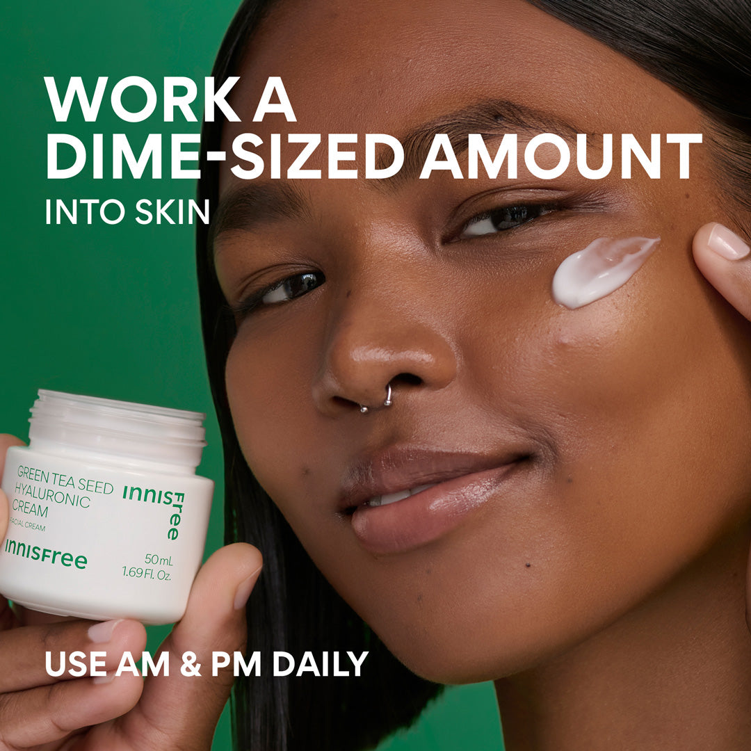 A close-up of a woman holding an Innisfree Green Tea Seed Hyaluronic Cream jar against a bright green background, with white text reading 'WORK A DIME-SIZED AMOUNT INTO SKIN' and 'USE AM & PM DAILY'.