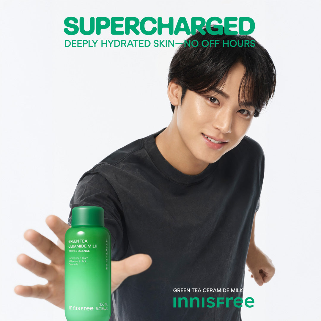 Korean Idol MINGYU in a black shirt extends his hand toward Green Tea Ceramide Milk, with large green text reading 'SUPERCHARGED' and smaller text 'DEEPLY HYDRATED SKIN - NO OFF HOURS' on a clean white background.