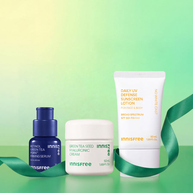 Three Innisfree skincare products arranged on a green gradient background with a green ribbon: Green Tea PDRN™ Serum, Green Tea Hyaluronic Cream, and a Daily UV Defense Sunscreen SPF 50+ 