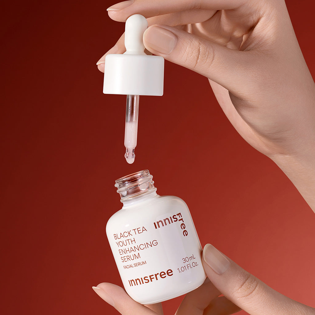 Hand model holding an opened Black Tea Serum