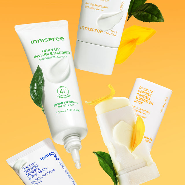 Four Innisfree sunscreen products arranged on a warm orange background with decorative green leaves and yellow flower petals.
