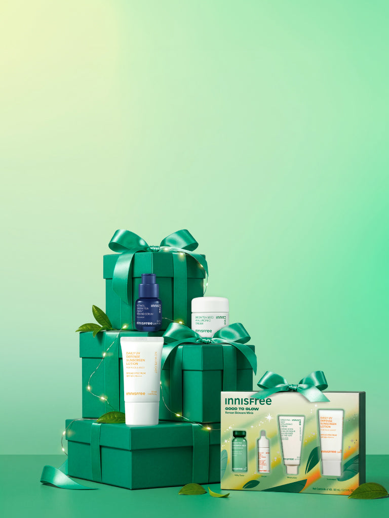 Innisfree Good to Glow Set and Green Tea PDRN™ Serum, Green Tea Hyaluronic Cream, and a Daily UV Defense Sunscreen SPF 50+ arranged with multiple green gift boxes tied with satin bows on a mint-green gradient background.