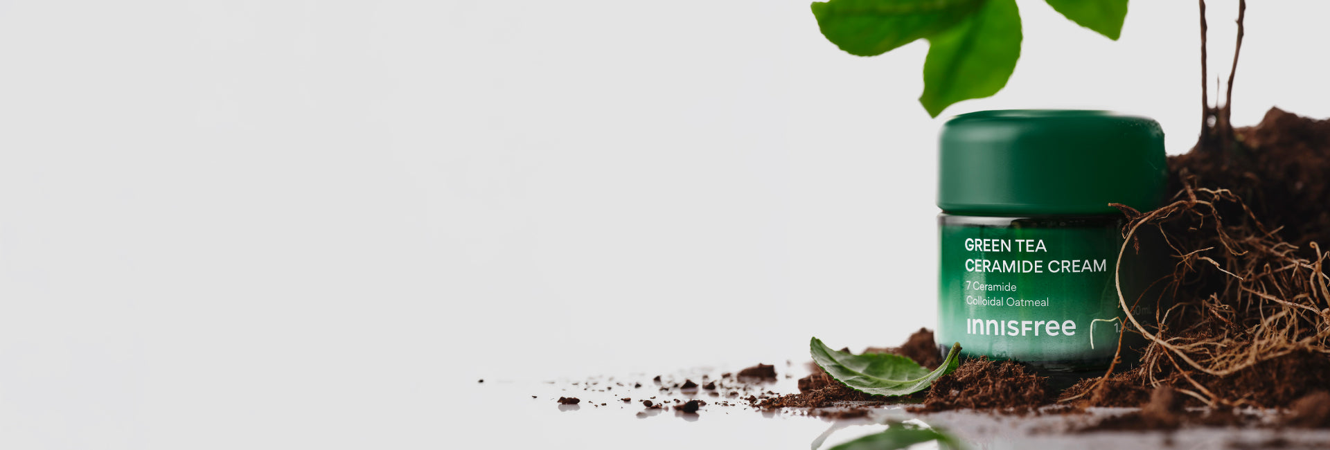 Green Tea Ceramide Cream with plant and soil background