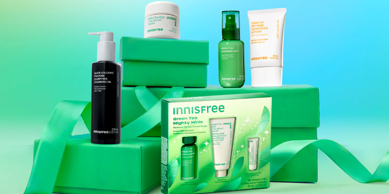 An Innisfree skincare gift set and products stacked green boxes with a green ribbon  arranged on stacked bright green boxes with a ribbon. 