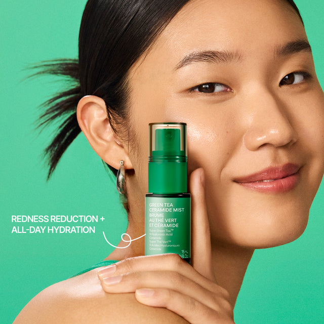 A woman with dark hair pulled back holds a green bottle of innisfree Green Tea Ceramide Mist 15mL against a solid green background. White text on the left reads 'REDNESS REDUCTION + ALL-DAY HYDRATION'.