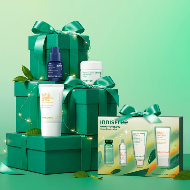 Innisfree Good to Glow Set and Green Tea PDRN™ Serum, Green Tea Hyaluronic Cream, and a Daily UV Defense Sunscreen SPF 50+ arranged with stacked teal gift boxes and green ribbons on a mint green background. 